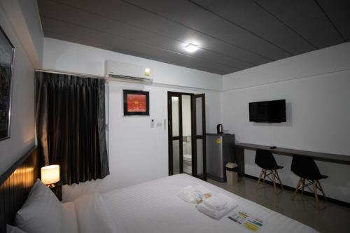 a hotel room with a bed and a television at The 168 Gallery Residence and Hotel in Chiang Mai