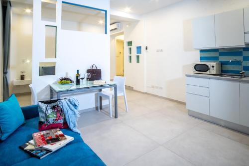 a living room with a blue couch and a kitchen at LEONE ROSSO APARTMENTs in Sorrento