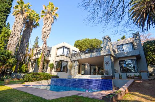 ジャーミストンにある112 on Kloof Villaのヤシの木が植えられた家の外観