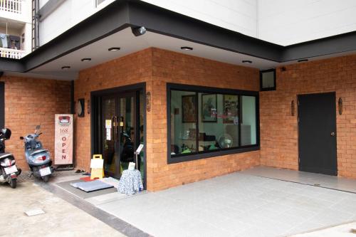 a brick building with a motorcycle parked in front of it at The 168 Gallery Residence and Hotel in Chiang Mai