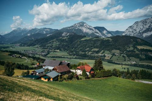 a village on a hill with mountains in the background at Bio-Landhaus Kesslerhof in Gröbming