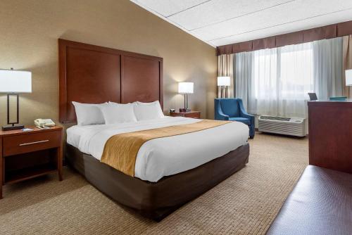 a hotel room with a large bed and a blue chair at Comfort Inn Lancaster County North in Denver
