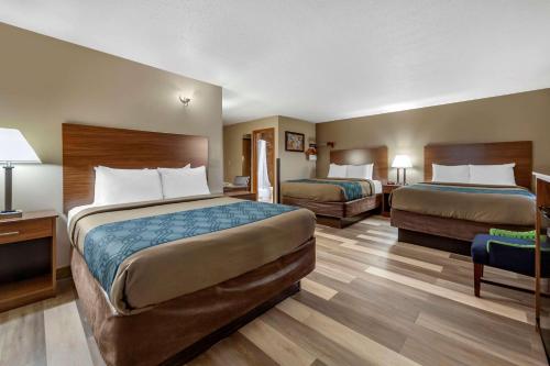 Habitación de hotel con 2 camas y escritorio en Econo Lodge Hays I-70 en Hays