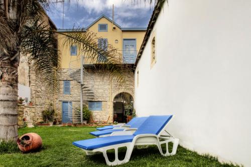 a group of blue lounge chairs in front of a building at Alkisti City Hotel in Larnaka