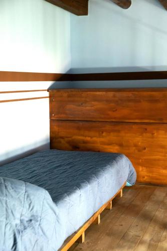 a bed with a wooden headboard in a room at Fardella 250 in Trapani