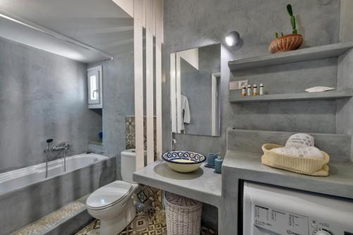 a bathroom with a sink and a toilet and a tub at Marconi's seaside villa in Megas Gialos - Nites