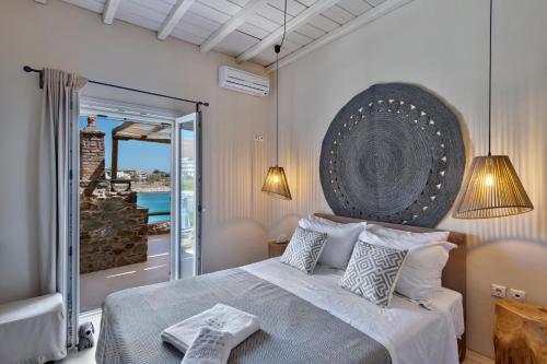 a bedroom with a large bed with a view of the ocean at Marconi's seaside villa in Megas Gialos - Nites