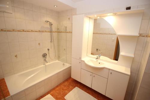 een badkamer met een bad, een wastafel en een bad tubermottermott bij Eva Dabernig in Zell am Ziller