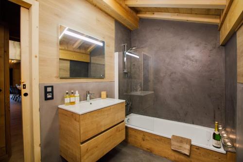 a bathroom with a sink and a shower and a tub at Chalet Melodie in Morzine