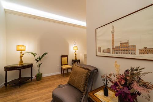 a living room with a chair and a table at Il giardino di Pantaneto Residenza D'Epoca in Siena