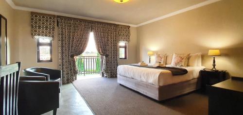a bedroom with a bed and a chair and a window at Accolades Boutique Venue in Midrand