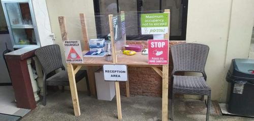 a wooden table with two chairs and signs on it at Melronz inn in Oslob