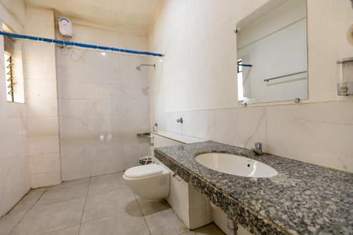a bathroom with a sink and a toilet and a mirror at Vivaant Retreat and Conventions in Igatpuri