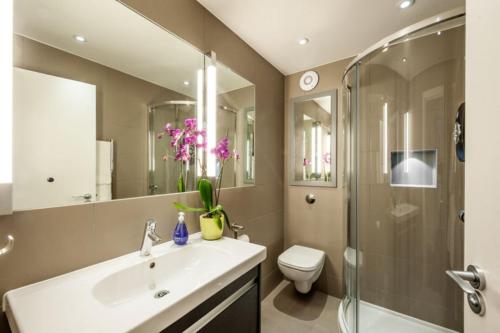 a bathroom with a sink and a shower and a toilet at Marylebone - Chiltern Street by Viridian Apartments in London