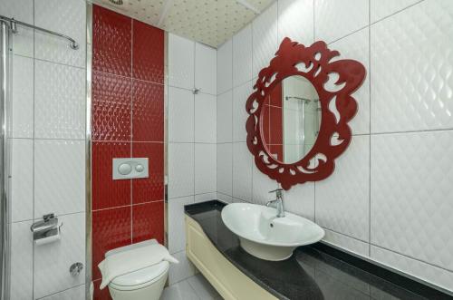 a bathroom with a sink and a mirror and a toilet at Majestic Hotel in Oludeniz