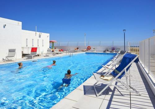 un groupe de personnes dans une piscine dans l'établissement Résidence Néméa Les Carrats - Port Leucate, à Port-Leucate