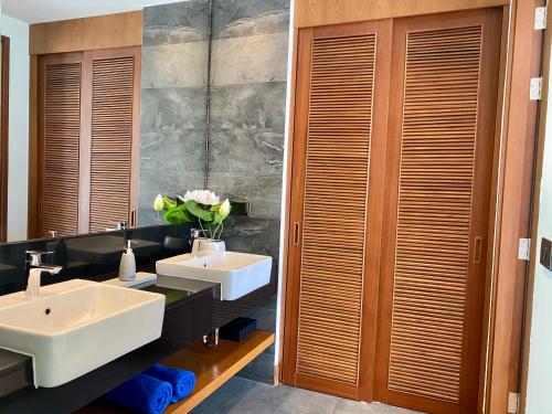 een badkamer met twee wastafels en een spiegel bij Villa Tango Victoria Resort, Koh Yao Noi in Ko Yao Noi