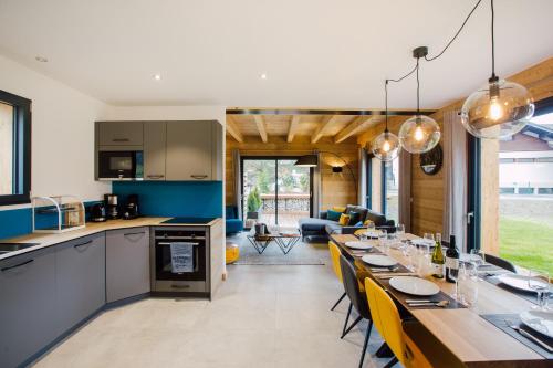 Il comprend une cuisine et un salon avec une longue table à manger. dans l'établissement Chalet Soleil d'Or, à Montriond