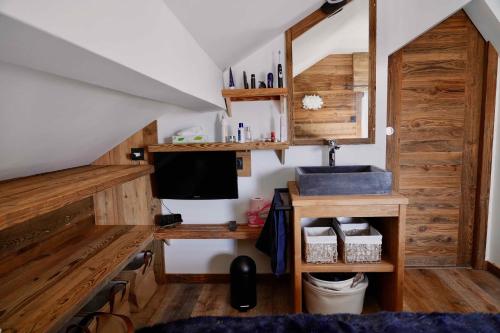 Cette chambre dispose d'un lavabo et d'un bureau avec une télévision. dans l'établissement SUPERBE DUPLEX 4* DERNIER ETAGE 7pers. / 67m2, à Huez