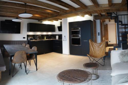 une cuisine et un salon avec une table et des chaises dans l'établissement SUPERBE DUPLEX 4* DERNIER ETAGE 7pers. / 67m2, à Huez