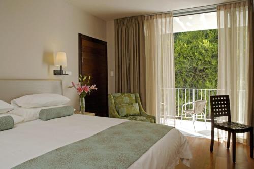 a hotel room with a bed and a balcony at Chapmans Peak Beach Hotel in Hout Bay