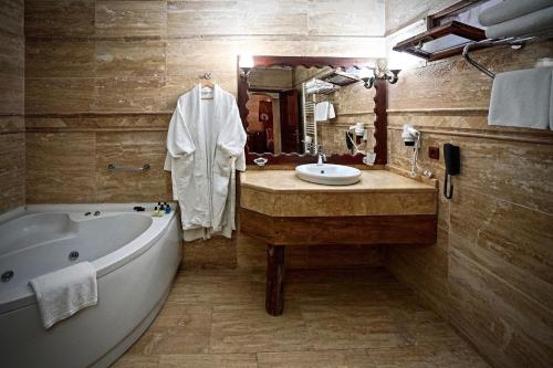 a bathroom with a tub and a sink and a bath tub at Melis Cave Hotel in Ürgüp