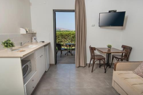 a kitchen and living room with a couch and a table at Degania Bet Kibbutz Country Lodging in Kinneret
