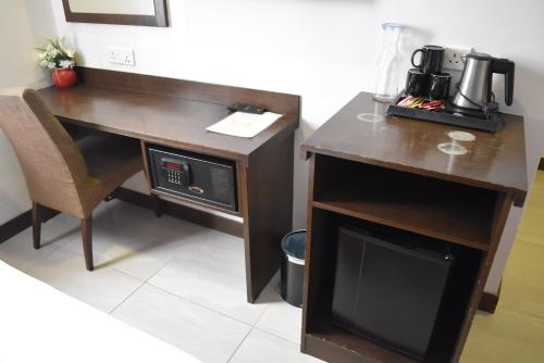 a desk with a microwave next to a table with a computer at Sunrise Hotel in Petaling Jaya