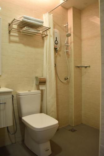 a bathroom with a toilet and a shower at Sunrise Hotel in Petaling Jaya