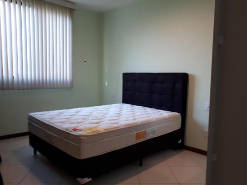 1 dormitorio con 1 cama en una habitación con ventana en Cobertura duplex vista mar 02 quartos Wi-fi TV Smart Temporada Cabo Frio, en Cabo Frío