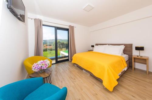 - une chambre avec un lit, une chaise et une fenêtre dans l'établissement Villa Holiness a luxury villa in Dubrovnik, tennis court, à Mlini