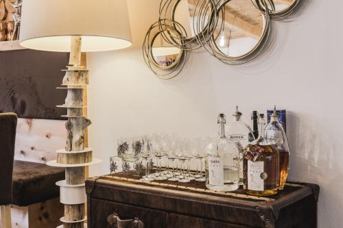 a table with a bunch of bottles and glasses at Hotel Chalet S - Dolomites Design - adults recommended in Selva di Val Gardena
