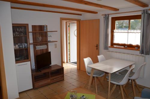 een keuken en eetkamer met een tafel en een televisie bij Alte Scheune Koserow App. 1 in Ostseebad Koserow