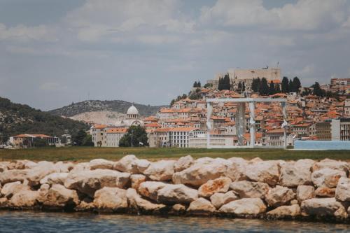 a group of rocks in the water in front of a city at D-Resort Šibenik in Šibenik