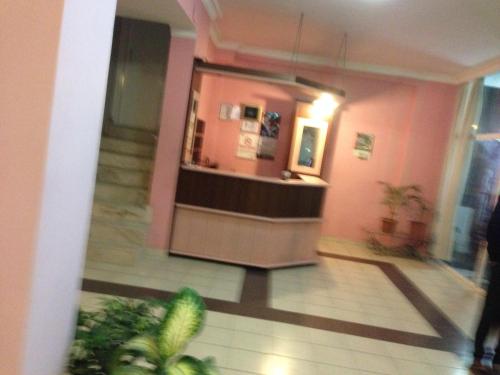 hol z ladą w różowym budynku w obiekcie Hotel Beyhan w mieście Mersin