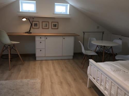 een slaapkamer met een bed en een tafel en stoelen bij Oak Tree Studio in Marlow