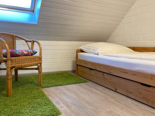 ein kleines Schlafzimmer mit einem Bett und einem Stuhl in der Unterkunft Ferienhaus Ostseekrabbe in Insel Poel