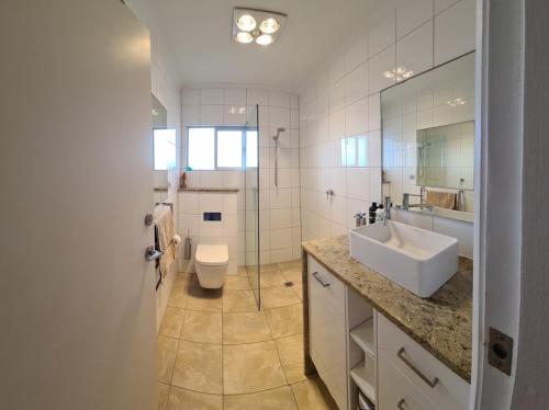 uma casa de banho com um lavatório, um WC e um espelho. em Acushla Accommodation Esplanade Living Self Check-In Self Check-Out em Adelaide
