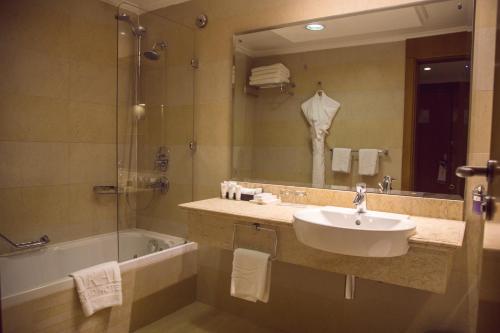 a bathroom with a sink, toilet and bathtub at Coral Baghdad Hotel in Baghdād