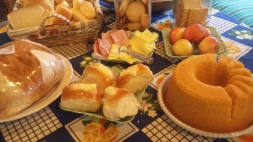 een tafel met borden van verschillende soorten levensmiddelen bij Chalés Recanto da Aldeia in Itanhaém