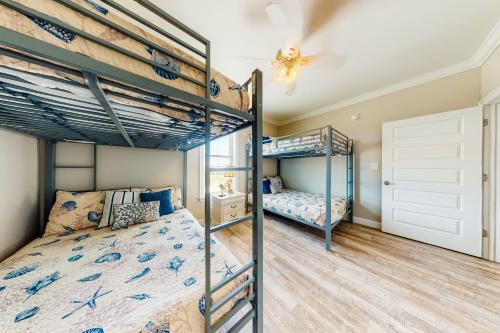 a bedroom with two bunk beds and a ceiling at License to Chill in Dauphin Island