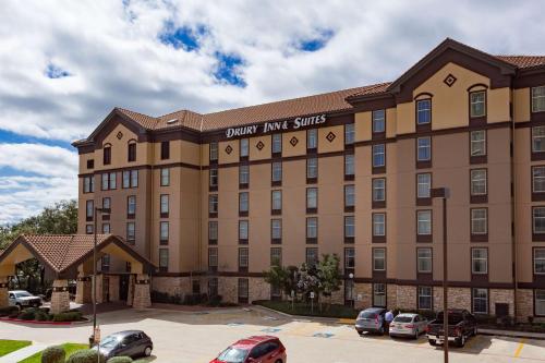 a large building with cars parked in a parking lot at Drury Inn & Suites San Antonio North Stone Oak in San Antonio