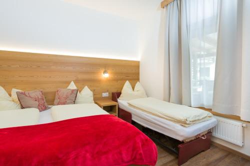 a hotel room with two beds and a window at Jägerhaus in Pellizzano