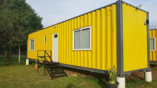 ein gelbes winziges Haus auf einem Feld in der Unterkunft TERRABOX Apart de contenedores in Olivera