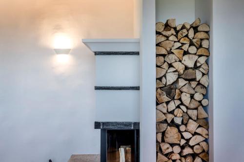 a wall with a pile of fire wood next to a fireplace at Chiemsee Chalet in Frasdorf