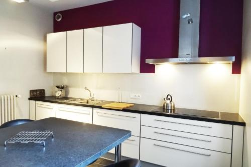 a kitchen with white cabinets and a counter top at VILLA EPERONNIERE in Nantes
