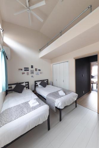 two beds in a room with white walls at SORAPIA Villa Mt.FUJI Front in Fujikawaguchiko