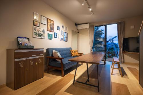 uma sala de estar com uma mesa e um sofá em SORAPIA Villa Mt.FUJI Front em Fujikawaguchiko