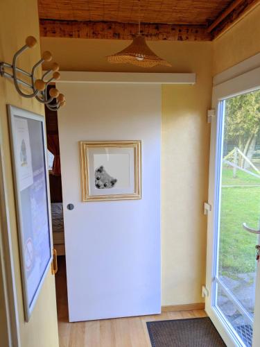 a hallway with a white door and a window at Chalets des Trois Hêtres in Plombières-les-Bains
