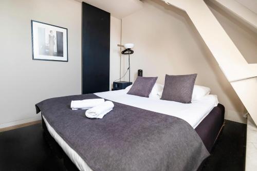 a bedroom with a large bed with two towels on it at AmsterHome Hotel in Amsterdam